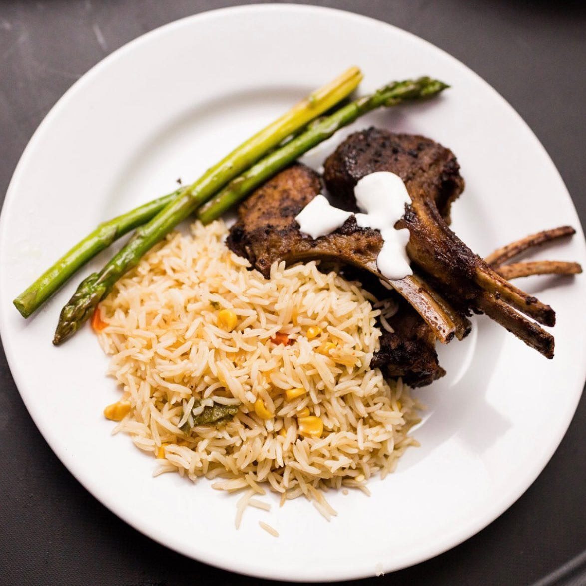 Herb-crusted lamb chops, plated with rice