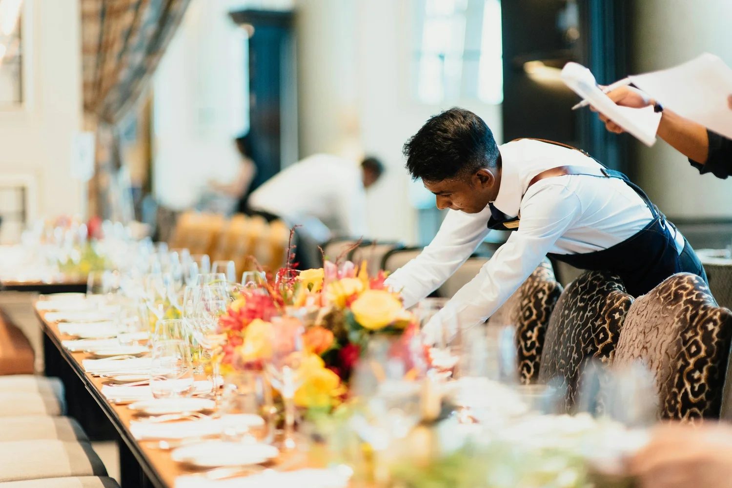 A team member setting a long dinner table