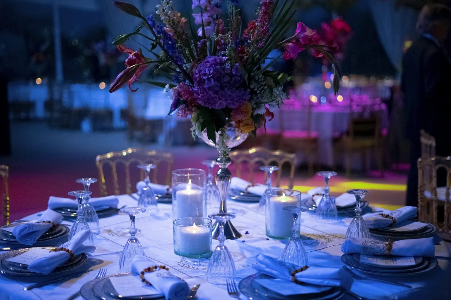 A reception room set with florals and candles in blue light