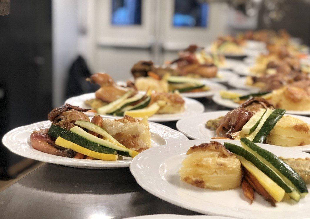 Plated dinners lined up at the pass, ready to go out together