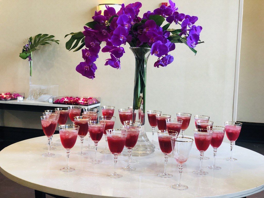 Rum punch in gold-rimmed glasses beside purple orchids