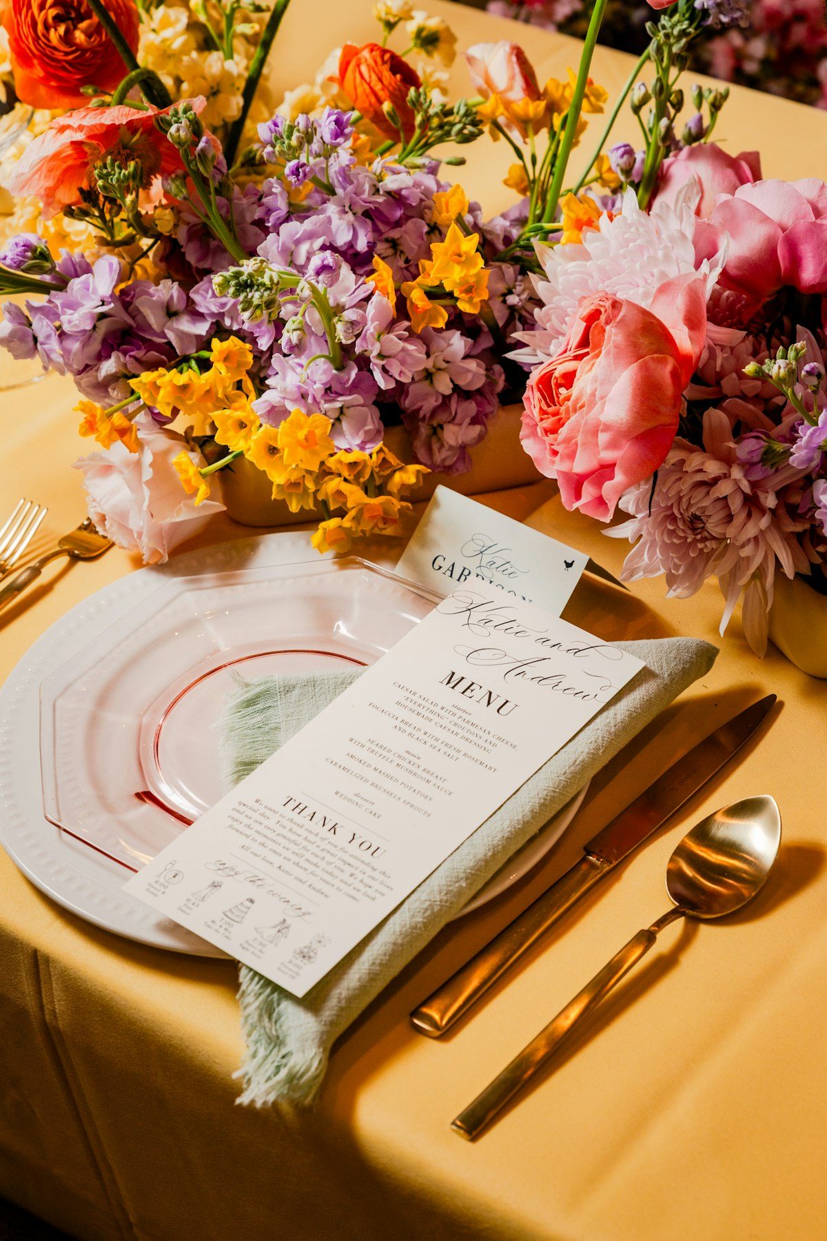A colourful place setting with florals and a menu card