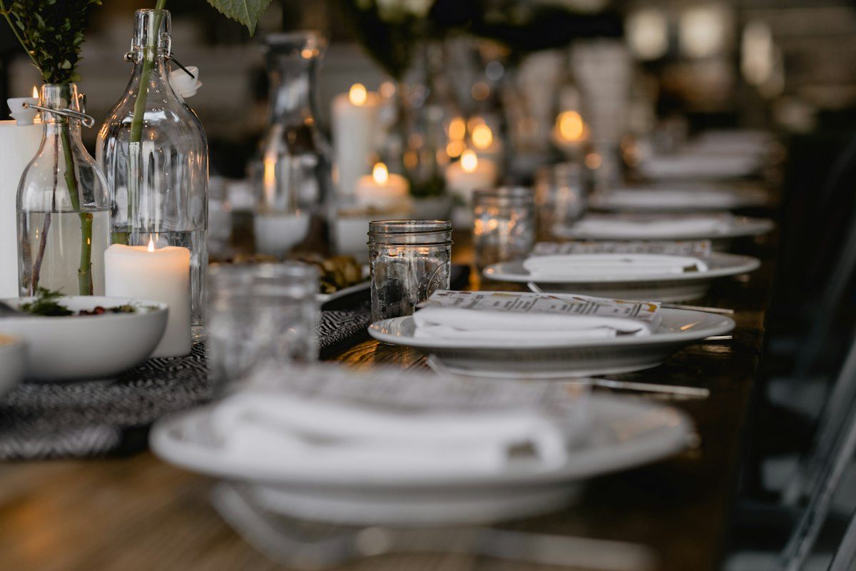 A long candlelit table set for dinner